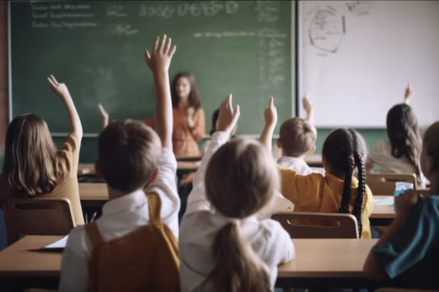 a classroom with children raising their hands in the air at The parcHAUS at Mustang Drive