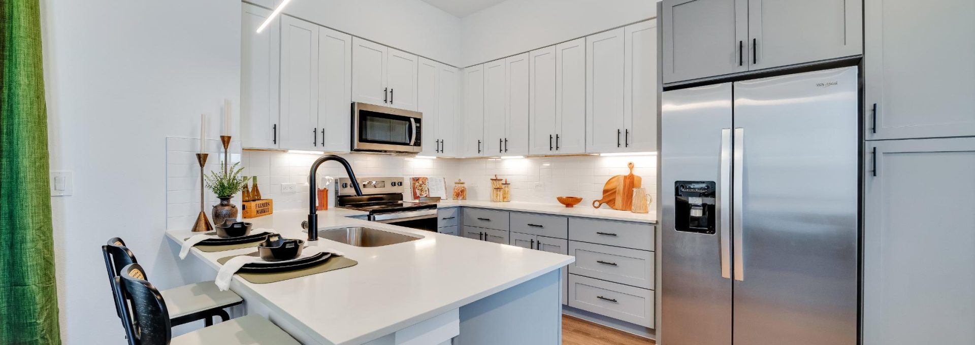 a kitchen with stainless steel appliances and wood floors at The parcHAUS at Mustang Drive